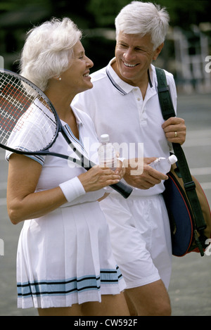 Coppia senior insieme a un campo da tennis Foto Stock