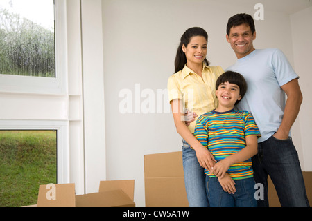 Ragazzo con i suoi genitori in una stanza e sorridente Foto Stock