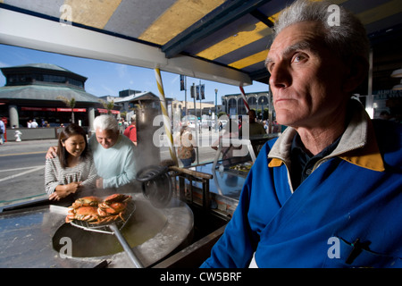 Uomo maturo con una coppia matura guardando i granchi essendo cotti in un ristorante, Fisherman's Wharf di San Francisco, California, Stati Uniti d'America Foto Stock