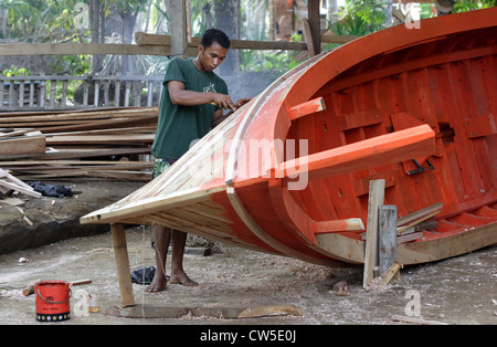 La sigillatura di giunti tra le doghe in legno nel tradizionale costruzione navale Foto Stock