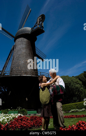 Coppia matura che abbraccia ogni altra e sorridente in un parco Golden Gate Park di San Francisco, California, Stati Uniti d'America Foto Stock