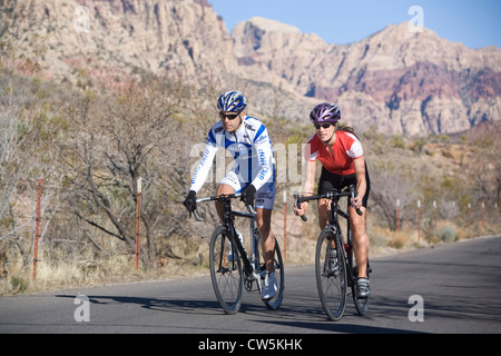 Coppia giovane equitazione biciclette attraverso un deserto