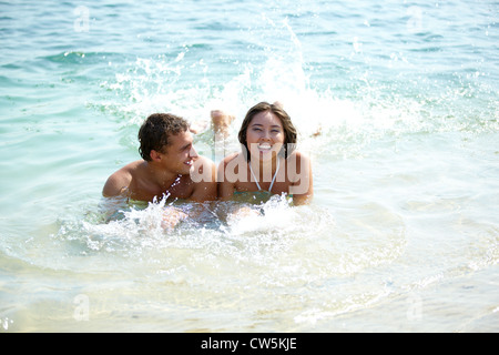 Ritratto di una coppia felice che giace in acqua calda e gioiosa ragazza ridere Foto Stock