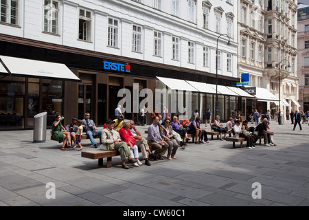 La gente seduta su una panchina di Graben, Vienna Foto Stock