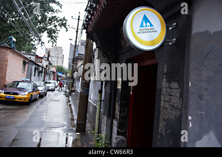 Segno per la International Youth Hostel lungo un hutong lane in un tradizionale cortile home chiamato siheyuan a Pechino in Cina Foto Stock