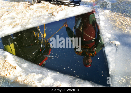 Foro triangolare nel lago ghiacciato, ghiaccio mirroring del subacqueo sulla superficie dell'acqua, in Germania, in Renania settentrionale-Vestfalia, Steinbach-Talsperre, Euskirchen Foto Stock