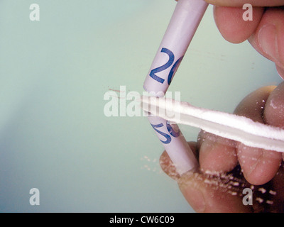 L uomo lo sniffing cocaina con laminati banconota Foto Stock