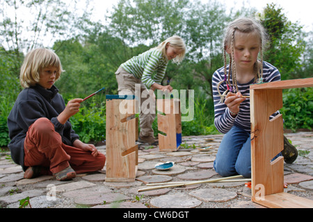 I bambini sono la realizzazione di un disidratatore apple; i bambini sono la verniciatura loro finito di apple disidratanti in colori luminosi, Germania Foto Stock