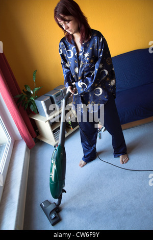 Donna che utilizza un aspirapolvere Foto Stock