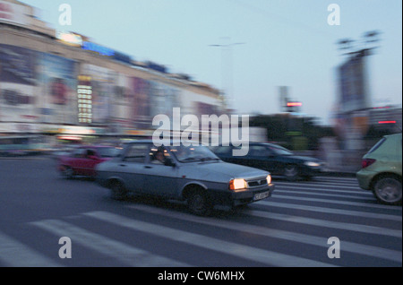 Il traffico della città presso l'unità quadrata (Piata Unirii) a Bucarest Foto Stock