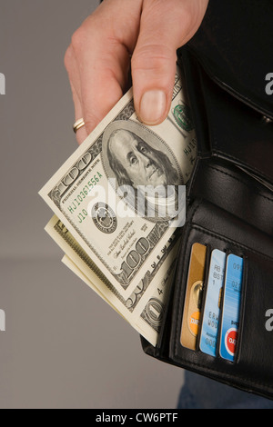 L'uomo prendendo Dollar banconote fuori del suo billfold, USA; Amerika Foto Stock