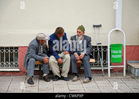 Tre vecchio seduto su una panchina e chat, Turchia, Anatolia Orientale, Yusufeli Foto Stock