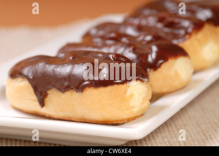 Deliziosa casa eclairs con glassa al cioccolato Foto Stock