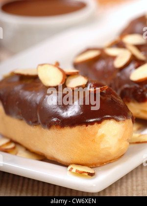 Deliziosa casa eclairs con glassa al cioccolato e mandorle Foto Stock