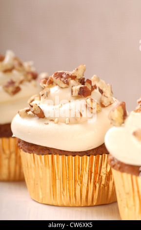 Una deliziosa torta di carote tortine con la glassa di formaggio cremoso e il trito di noci pecan Foto Stock