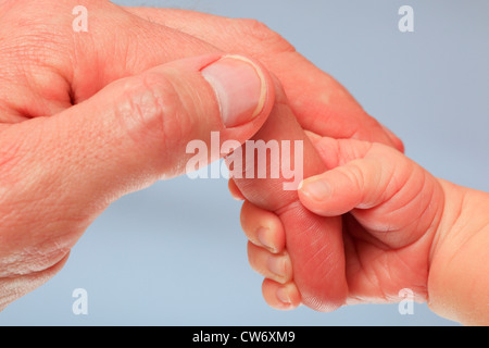 Un bambino tenendo la mano del padre indice Foto Stock