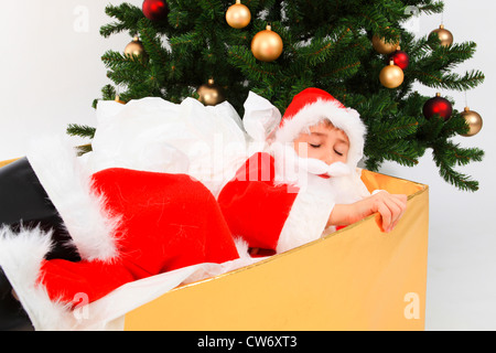 Little Boy vestito come Babbo Natale giacente esaurito in una scatola, Svizzera Foto Stock