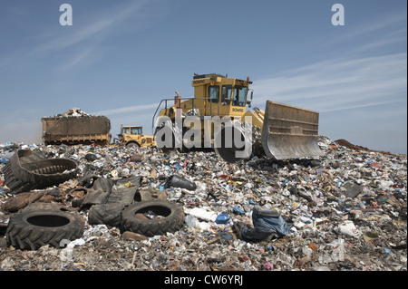 Bulldozer e un camion pieno di immondizia in un impianto di smaltimento dei rifiuti, Regno Unito, Scozia, Edimburgo Foto Stock