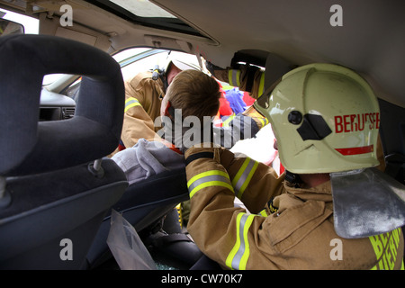 Formazione dei vigili del fuoco e di assistenza medica di emergenza i tecnici in un incidente con una persona ferita Foto Stock