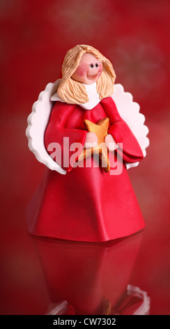 Un po' di Christmas Angel ornamento su uno sfondo di colore rosso. Foto Stock