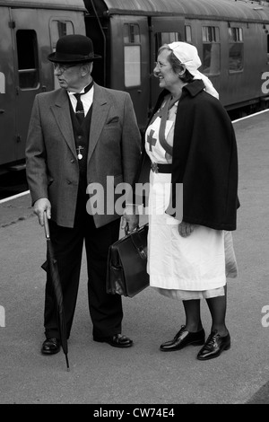 Infermiere degli anni quaranta civili e sulla piattaforma con il treno Foto Stock