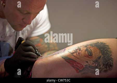 Tattooer tatooing un uomo con la schiena, Germania Foto Stock