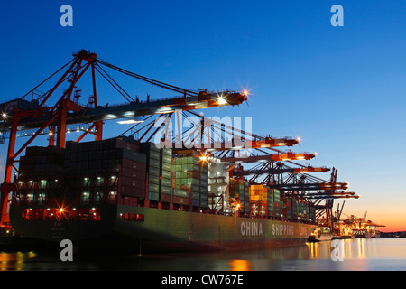 Cotainer nave nel porto di Amburgo al tramonto, Germania Amburgo Foto Stock