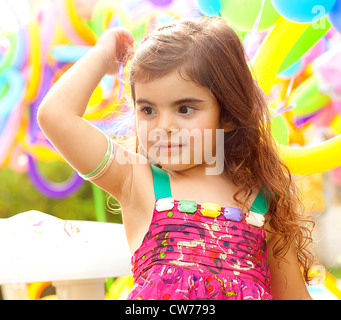 Closeup ritratto di giocoso dolce femmina piccolo bambino, 3-anno vecchia ragazza festa di compleanno, adorabile piuttosto il capretto con mano Foto Stock