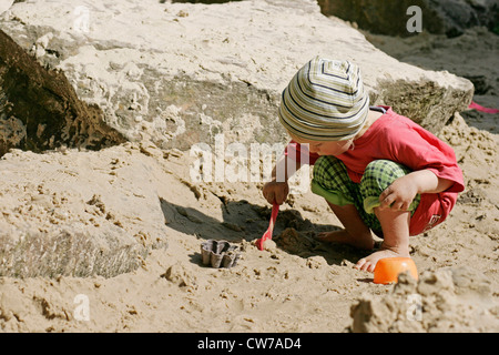 Piccolo bambino che gioca nella sabbia bagnata, Germania Foto Stock