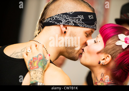 Giovane con tatuaggi kissing Foto Stock