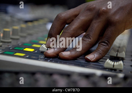 Mano di un ingegnere audio al mixer presso la stazione radio "Radio Isanganiro' popolari nel paese, Burundi Bujumbura Marie, Bujumbura Foto Stock