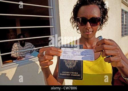 Giovane donna è appena diventato registrati per le elezioni nazionali del 2010 ed è fiera di presentare la conferma scritta e il Passaporto richiesto, Burundi Bujumbura Mairie, Bujumbura Foto Stock