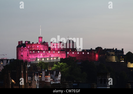 Castello di Edimburgo illuminato rosa al tramonto, Scozia Regno Unito Foto Stock