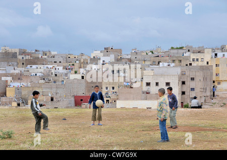 Ragazzi che giocano a calcio nella parte anteriore del povero quater, Marocco, Fes Foto Stock