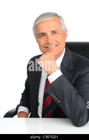 Ritratto di un successo imprenditore maturo seduti ad una scrivania con la sua mano sul suo mento. Foto Stock