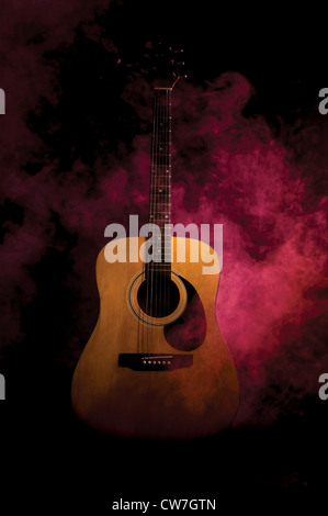 Chitarra acustica in fumo e stadio della luce ambiente Foto Stock