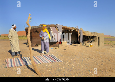 Due dei berberi di fronte al loro rifugio nel deserto, Marocco Foto Stock