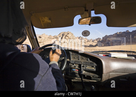 Vista dalla parte anteriore dello schermo di un veicolo fuoristrada essendo pilotati attraverso l Acacus montagne nel tuo deserto libico, Libia Foto Stock