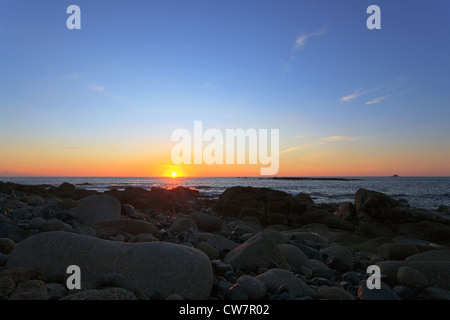 Guardando il tramonto sul mare, prese a Sennen Cove, Cornovaglia con la Brisons all'orizzonte. Foto Stock