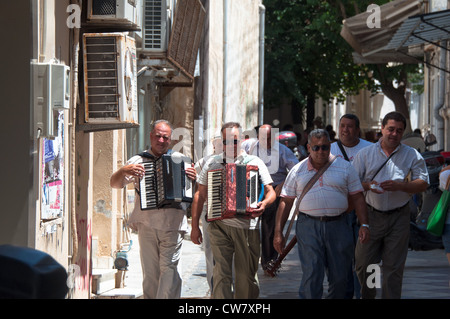Tipico greco musicisti di strada a piedi attraverso i vicoli del borgo ed eseguendo le loro canzoni per i turisti a Heraklion, Creta Foto Stock