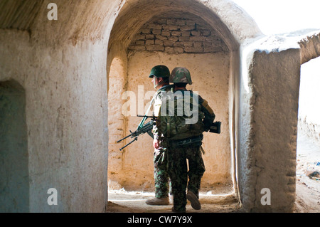 Soldati dell'esercito nazionale afgano cercano un composto mentre su una pattuglia del piede congiunta con i soldati del 2 ° Platoon, Apache Company, 1 ° Battaglione, 23 ° Reggimento di fanteria, 1 agosto 2012, nel sud dell'Afghanistan. Foto Stock