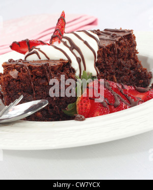 Brownie al cioccolato con panna e fragole. Foto Stock