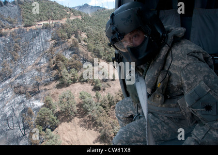 Sgt. Chris Boni, California esercito Guardia nazionale capo equipaggio da 1-140esimo battaglione aviazione (Air Assault) fuori Los Alamitos formazione congiunta di base (JFTB), rilascia l'acqua da sopra la testa mentre si combatte il fuoco di RIM in Kern County. La UH-60 equipaggio irrorato il cerchione al fuoco con un totale di 30,111 galloni passato tre giorni mentre combattendo il complesso di Jawbone di incendi a sostegno del Bureau of Land Management, Kern County fire e CAL FIRE. Foto Stock