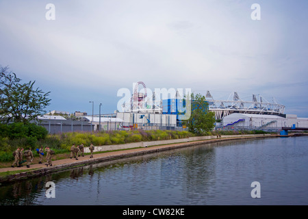 I militari di pattuglia lungo il fiume Lea che mostra lo Stadio Olimpico e orbita in Stratford il Parco Olimpico attraverso il canale. Foto Stock