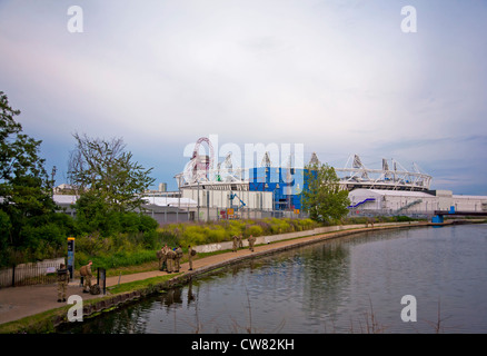 I militari di pattuglia lungo il fiume Lea che mostra lo Stadio Olimpico e orbita in Stratford il Parco Olimpico attraverso il canale. Foto Stock