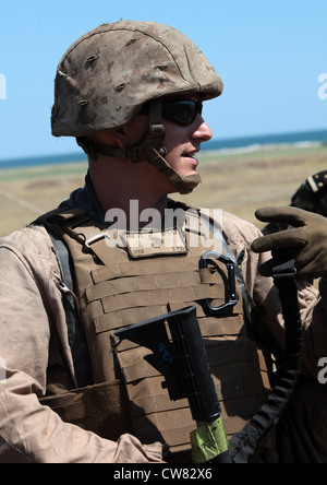 U.S. Marine Corps CPL. James Fink con la cooperazione di sicurezza Task Force Africa Partnership Station 2012 mette in mostra un carico di combattimento del corpo dei Marine per i media rumeni, mentre collabora con i Marines rumeni dal 307esimo Battaglione Navale di fanteria a seguito di un assalto alla spiaggia a Capu Midia, Romania, 12 agosto 2012. L'assalto alla spiaggia è stato l'evento finale dell'esercizio Summer Storm 12. Foto Stock