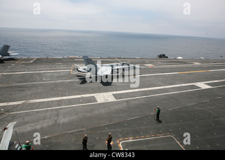 Un pilota con Marine Fighter Attack Training Squadron 101 prende un filo per atterrare a bordo della portaerei USS Nimitz durante un evento di allenamento, agosto 13. I piloti addestrati per qualificare il trapping, utilizzando il gancio di coda di un F/A-18 Hornet per afferrare i fili sul ponte di volo, durante l'allenamento diurno e notturno. Foto Stock