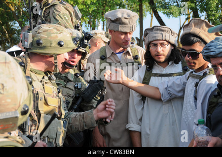 Soldati dell'esercito georgiano del 32° Battaglione di fanteria leggera parlano con civili locali durante un esercizio di prove di missione (MRE) presso il Joint Multinational Readiness Center di Hohenfels, Germania, 13 agosto 2012. Mres sono progettati per preparare unità per lo spiegamento al teatro afgano di operazioni per condurre operazioni di controrivellazione, stabilità e trasporto a sostegno della forza internazionale di assistenza alla sicurezza della NATO. Foto Stock