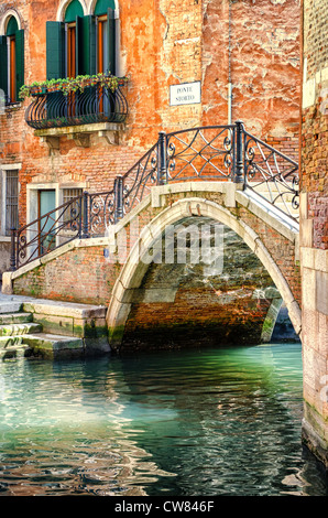 Un ponte su un tranquillo canale di Venezia, prima che i primi turisti del giorno sono circa. Foto Stock