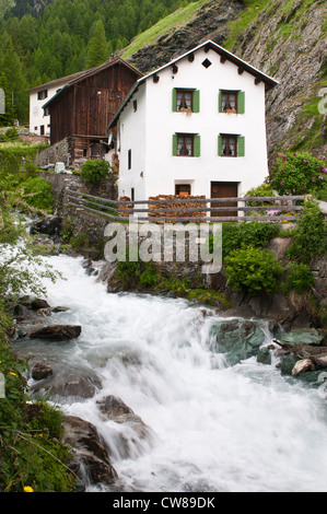 Ruscello di montagna e casa a Mulegns. Svizzera. Foto Stock